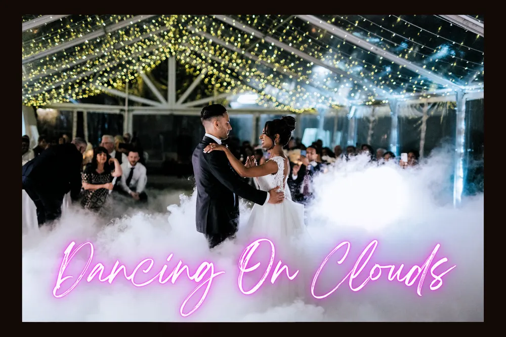 Bride and groom dancing on clouds beneath fairy lights